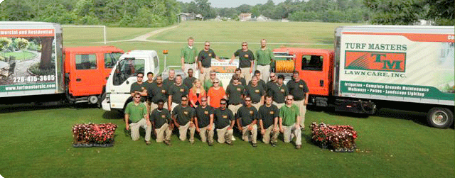 Turf Masters Lawn Care crew with branded fleet vehicles
